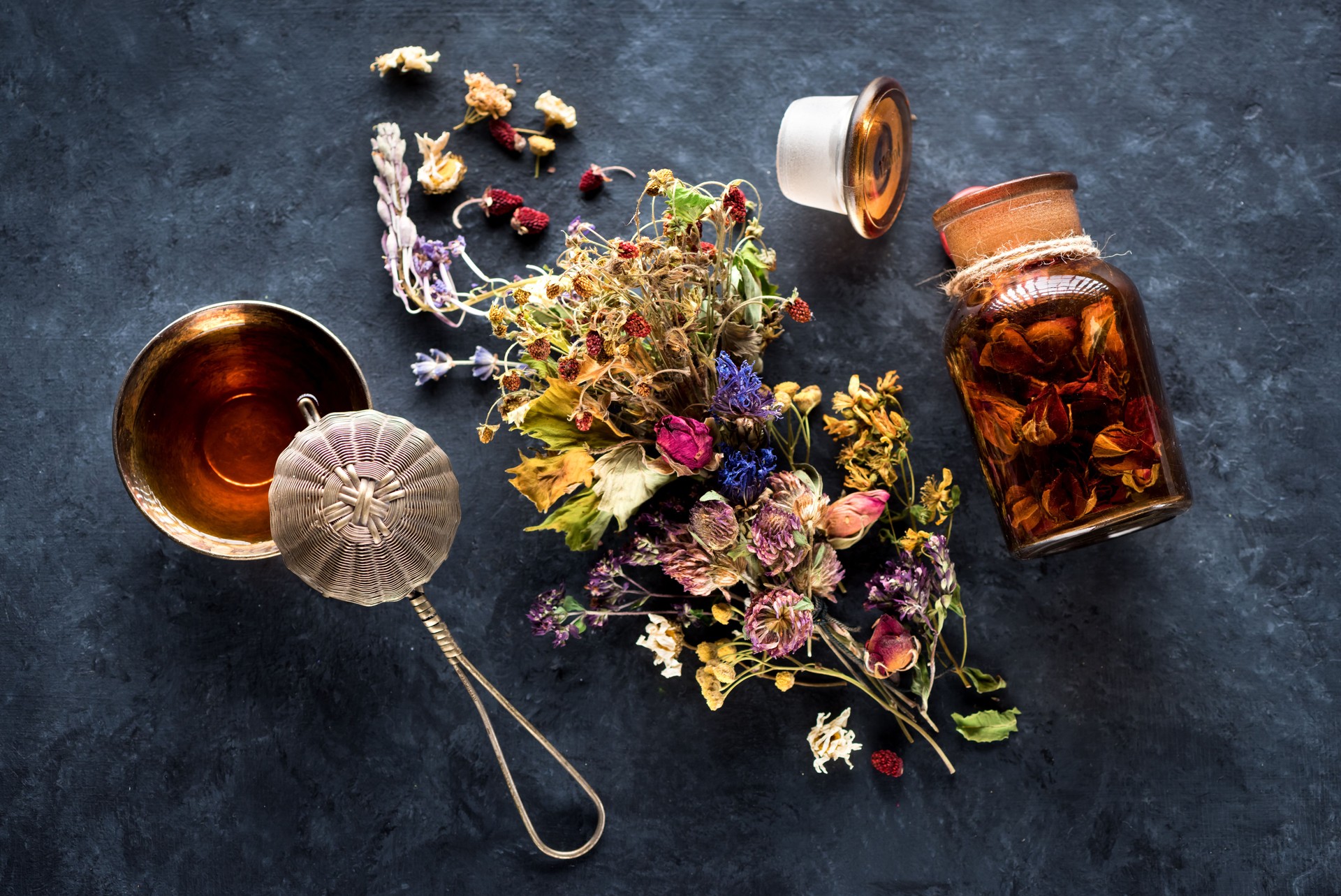 Dried herbs and flowers and herbal tea in a cup